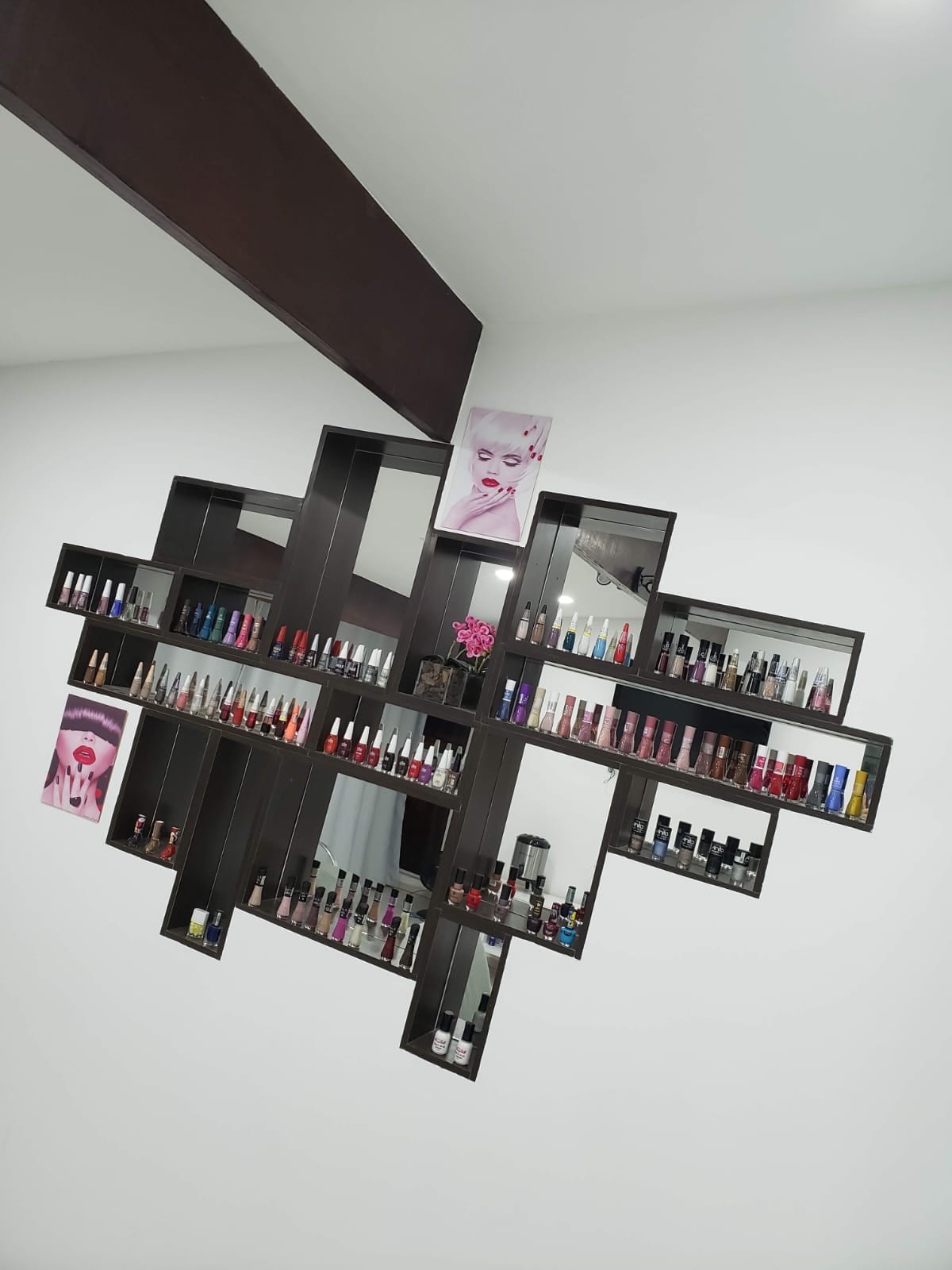 Prateleira com a colecao de esmaltes da Esmalteria Elegancy
